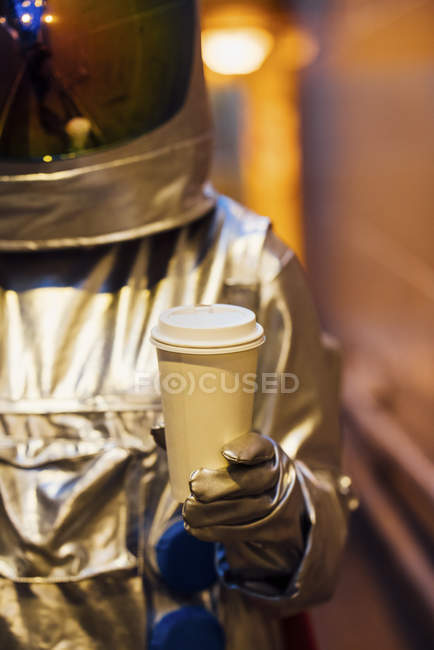 Primer plano del hombre del espacio en la ciudad por la noche la celebración de café para llevar - foto de stock