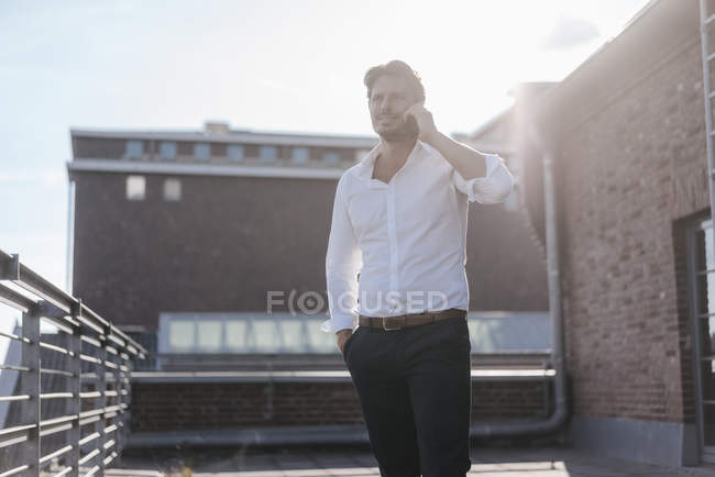 Empresário em pé no terraço, fazendo um telefonema — Fotografia de Stock