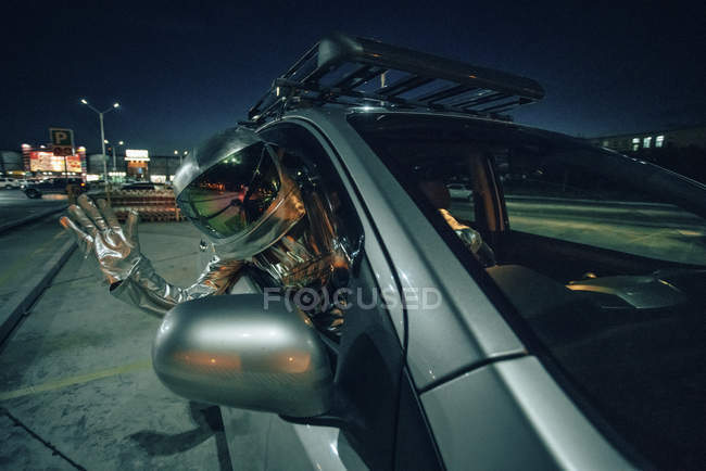 Homem do espaço acenando de carro à noite na cidade — Fotografia de Stock