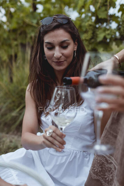 Donna versando vino in vetro su un picnic in natura — Foto stock