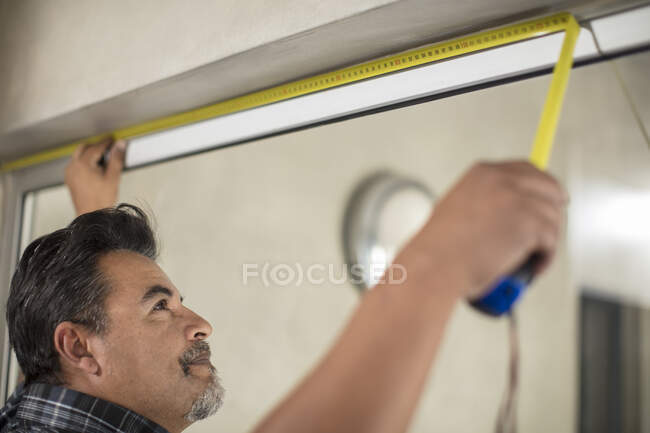 Homme mesurant cadre de fenêtre — Photo de stock