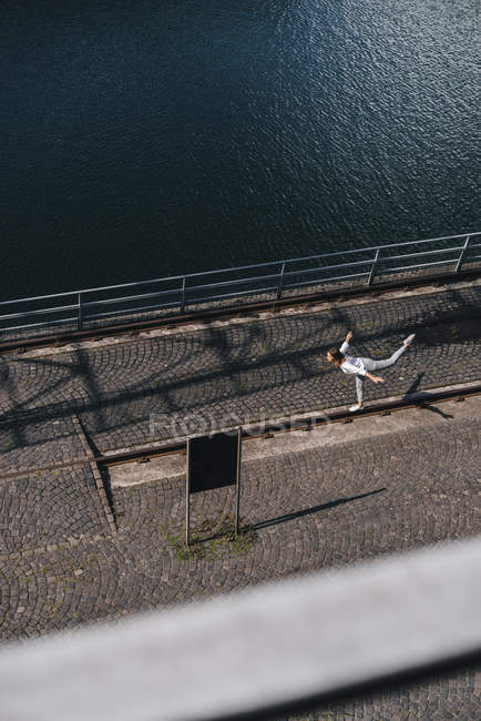 Geschäftsfrau steht am Fluss und balanciert auf einem Bein — Stockfoto