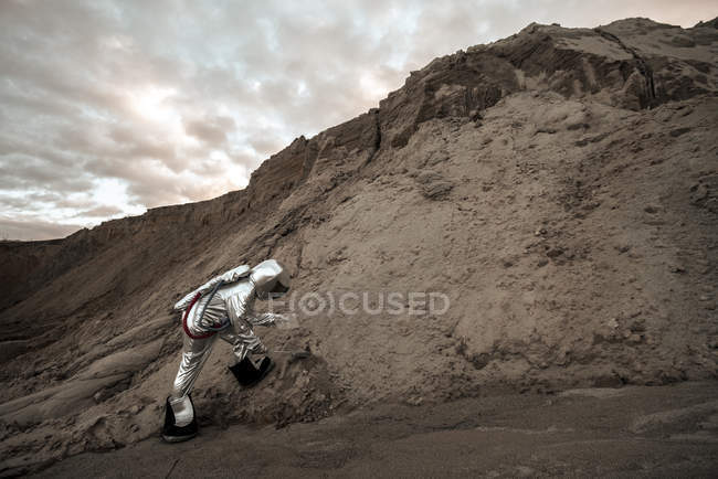 Raumfahrer auf namenlosem Planeten nimmt Sandprobe — Stockfoto