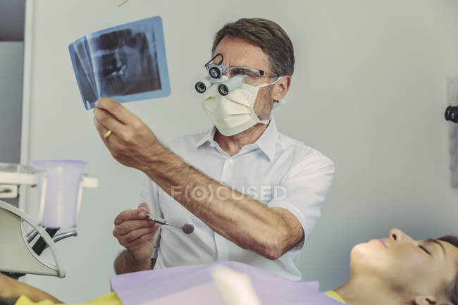 Dentista guardando l'immagine a raggi X prima del trattamento — Foto stock