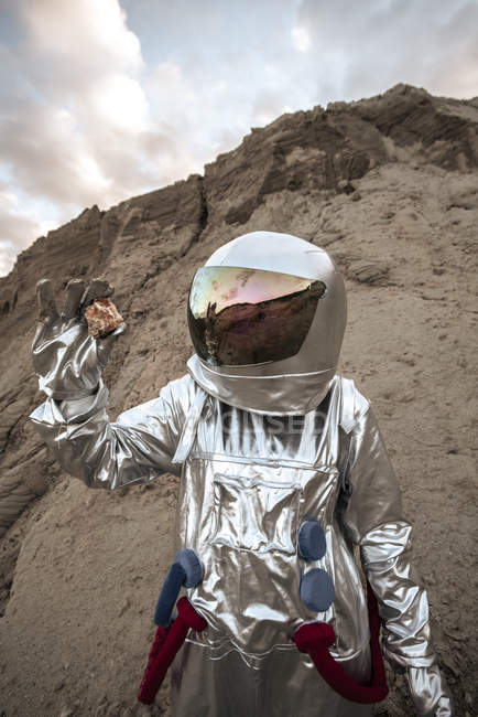 Hombre del espacio en el planeta sin nombre, tomando muestras de roca - foto de stock