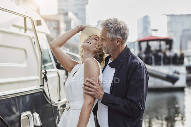 Uomo e giovane donna con differenza di età ridendo accanto allo yacht — Foto stock