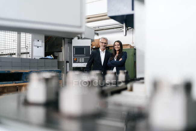 Businessman and businesswoman in high-tech enterprise, looking confident — Stock Photo