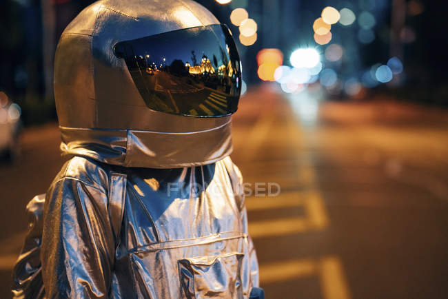 Homem do espaço de pé na rua na cidade à noite — Fotografia de Stock