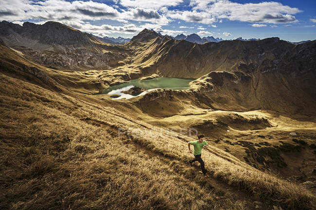 Германия, Альпы Альгеу, человек бежит по горной тропе — стоковое фото