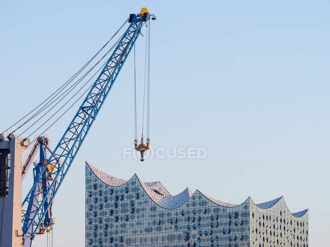 Germany, Hamburg, Elbe philharmonic hall with harbour crane in the foreground — Stock Photo