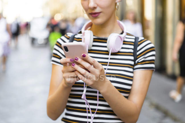 Femme utilisant un smartphone dans la rue, vue partielle — Photo de stock