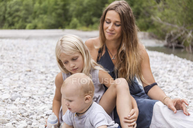 Madre con dos hijos al aire libre en la naturaleza - foto de stock