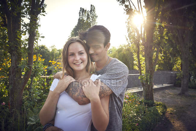 Feliz pareja joven coqueteando en un parque en verano - foto de stock