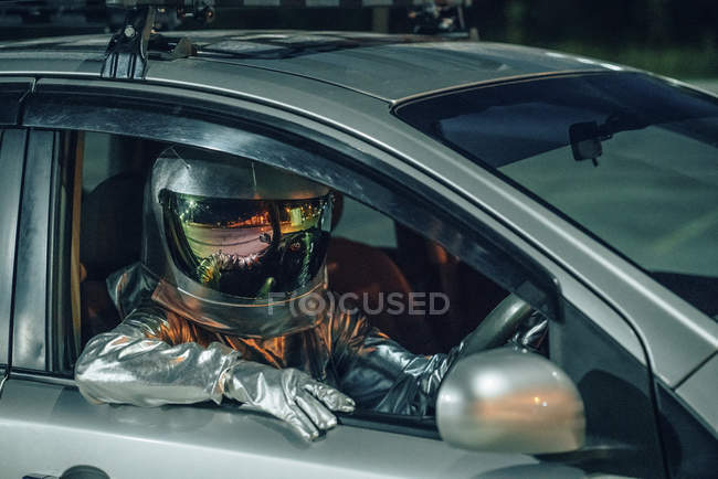 Close-up do homem do espaço sentado no carro à noite — Fotografia de Stock