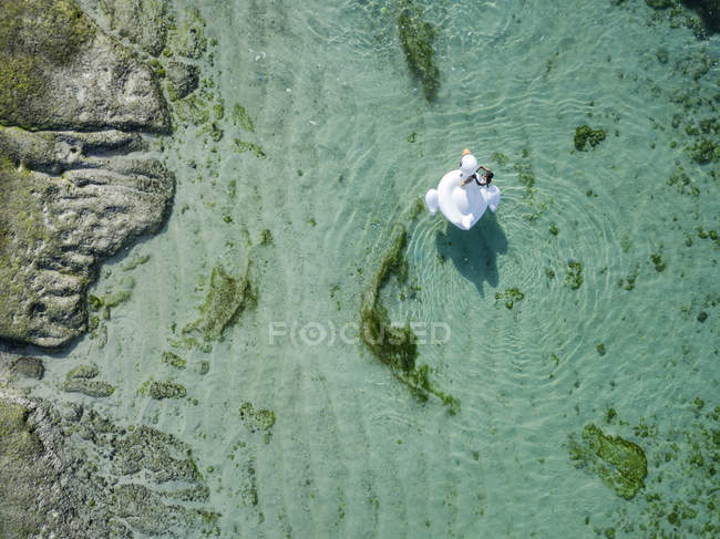 Indonesia, Bali, Aerial view of Karma Kandara beach, one woman, airbed floating on water — Stock Photo