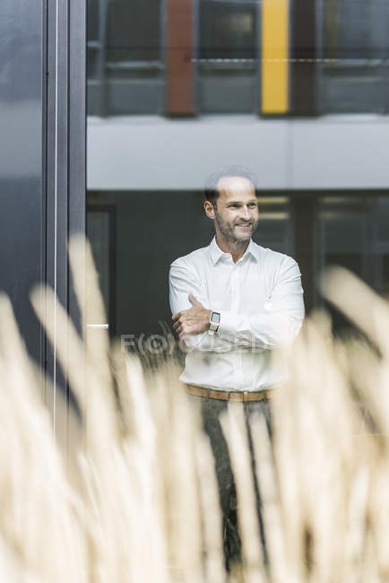 Ritratto di uomo d'affari sorridente che guarda fuori dalla finestra — Foto stock