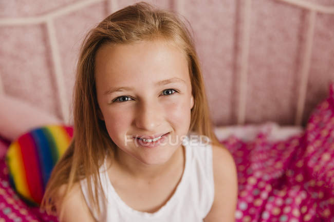 Ritratto di bambina sorridente in camera da letto — Foto stock