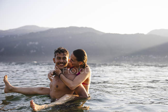 Glückliches, verspieltes junges Paar in einem See — Stockfoto