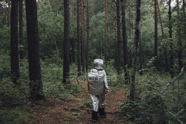 Spaceman exploring nature, walking in forest — Stock Photo