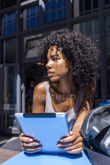 Young woman with digital tablet in city — Stock Photo