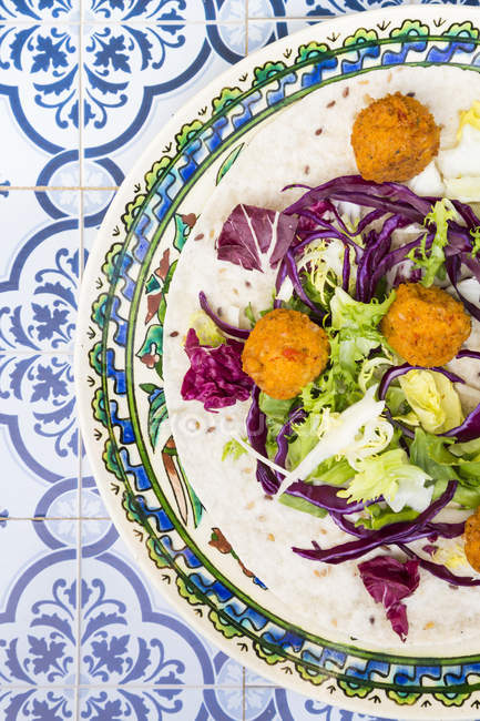 Falafel, leaf salad, red and white cabbage and yogurt sauce with mint on wrap — Stock Photo