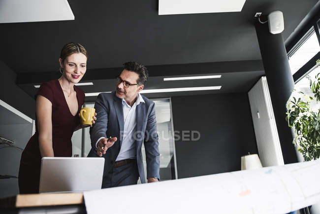 Підприємець і бізнесмен в офісі обговорювали з ноутбуком і план на столі — стокове фото