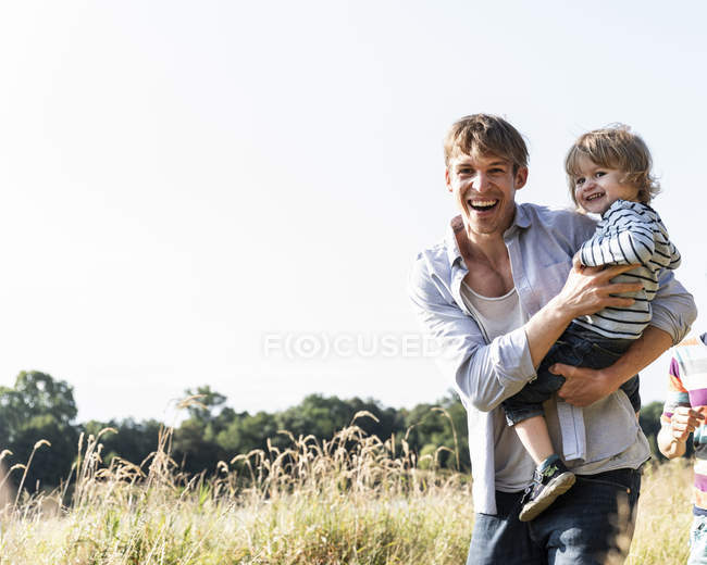 Отец и сын веселятся в летнем поле — стоковое фото