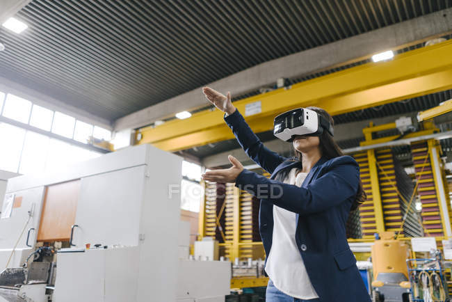 Молода жінка працює на складі дистрибуції, одягнена в окуляри VR — стокове фото