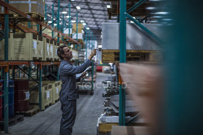 Worker in factory warehouse taking stock — Stock Photo