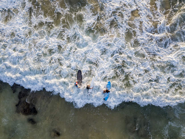 Indonesia, Bali, Aerial view of Dreamland beach, three surfers from above — Stock Photo