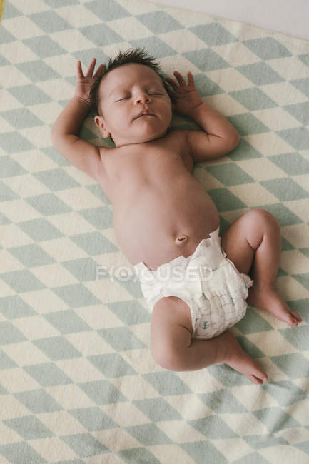 Новонароджений хлопчик лежить в підгузках на ковдрі — стокове фото