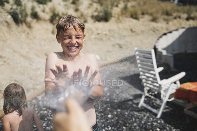 Портрет хлопчика, що сміється, розбризкується в саду — стокове фото
