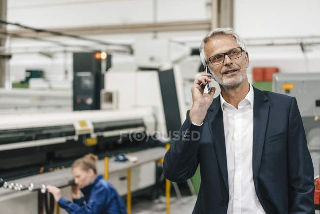 Manager talking on  phone, while woman working on background — Stock Photo