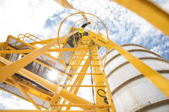 Trabajador en escalera en el tanque - foto de stock