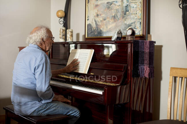 Hombre mayor tocando el piano en casa de retiro - foto de stock