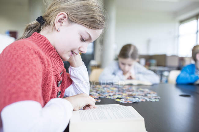 Estudante ler livro na mesa na sala de descanso da escola — Fotografia de Stock