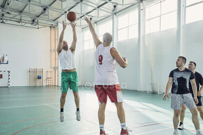 Hombres jugando al baloncesto, indoor - foto de stock