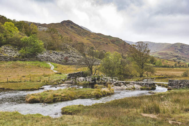 Royaume-Uni, Angleterre, Cumbria, Lake District, pont en pierre au-dessus de la rivière Brathay — Photo de stock