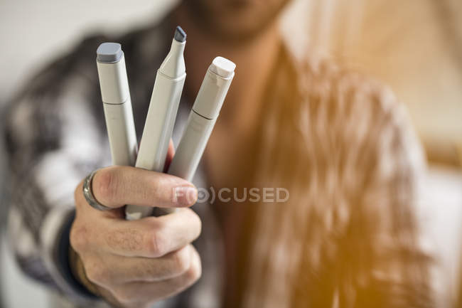 Close-up of artist holding pens — Stock Photo