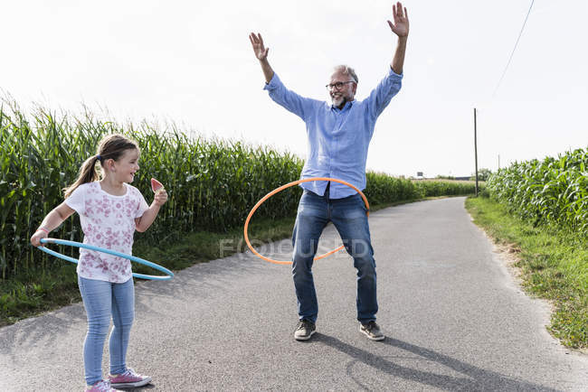 Nonno e nipote giocare con hoola hoop in strada — Foto stock