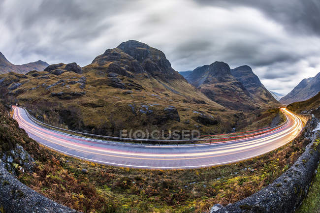 Regno Unito, Scozia, piste ciclabili su strada panoramica attraverso le montagne negli altopiani scozzesi vicino Glencoe al tramonto — Foto stock