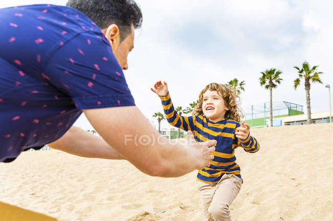 Espagne, Barcelone, garçon courant vers son père sur la plage — Photo de stock