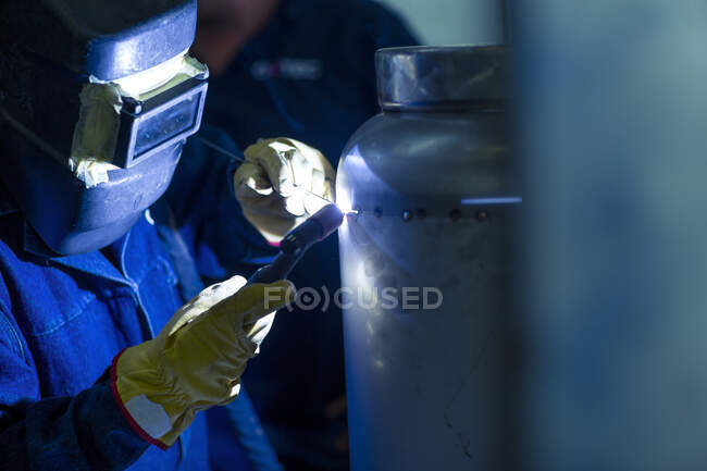 Welder in industrial plant welding tanks — Stock Photo