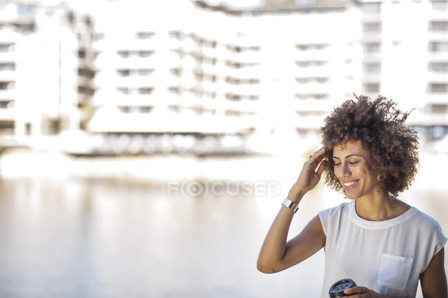 Junge Frau macht eine Pause im Freien, hält eine Tasse Kaffee in der Hand — Stockfoto
