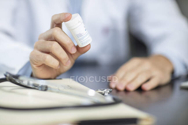 Доктор сидит за своим столом с таблетками — стоковое фото