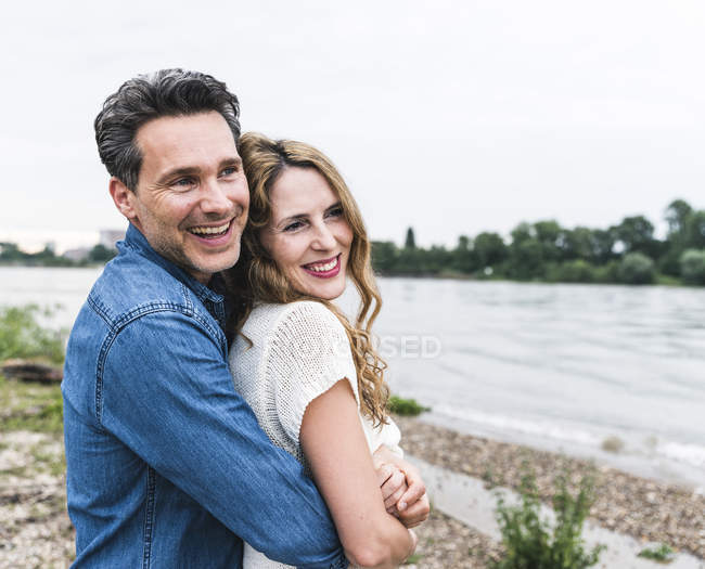 Happy affectionate couple at the riverside — Stock Photo