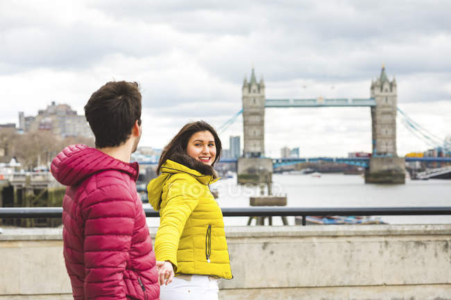 Reino Unido, Londres, jovem casal andando de mãos dadas sobre a ponte sobre o Tamisa — Fotografia de Stock