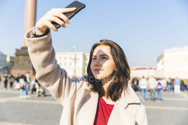 Росія, Санкт-Петербург, молода жінка з використанням смартфона в місті — стокове фото