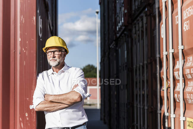 Uomo d'affari al porto di carico, con casco di sicurezza, braccia incrociate — Foto stock
