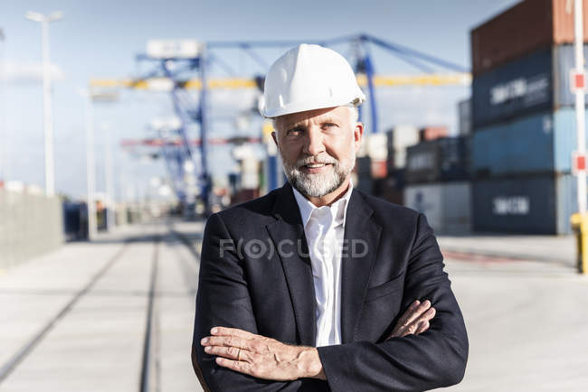 Бізнесмен на вантажному порту, носіння безпеки шолом, схрещеними руками — стокове фото